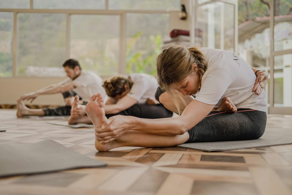 A group of students doing a stretch in a Pilates class