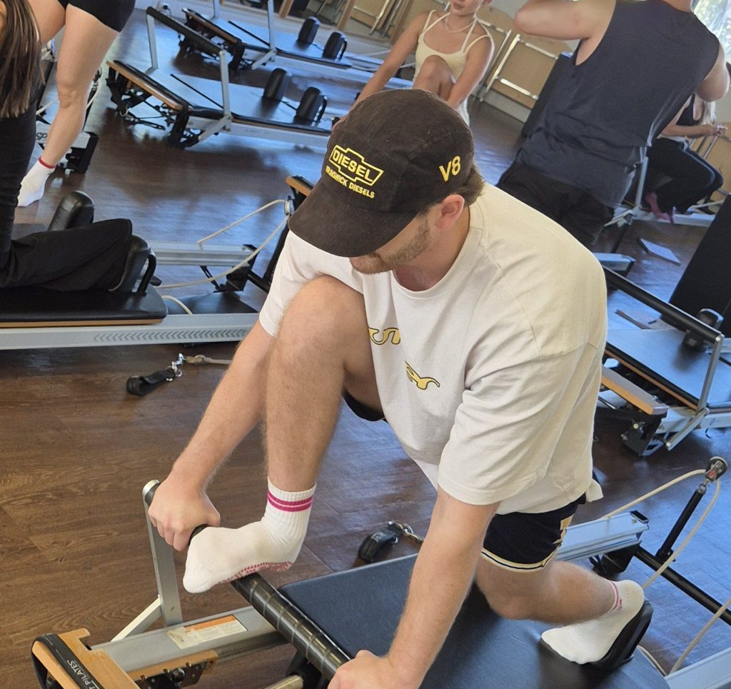 Pilates for Men | The Pilates League Man doing reformer Pilates exercises