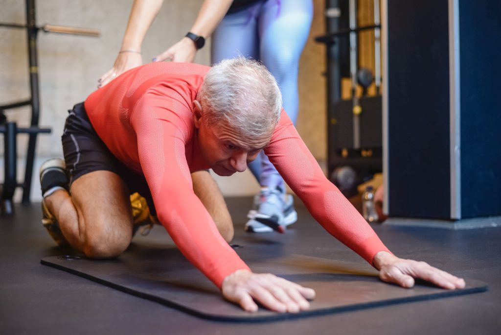 Pilates for Men | The Pilates League man in childs pose at Pilates