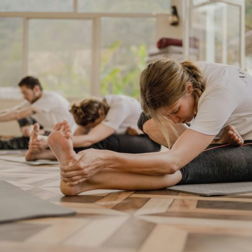 A group of students doing a stretch in a Pilates class
